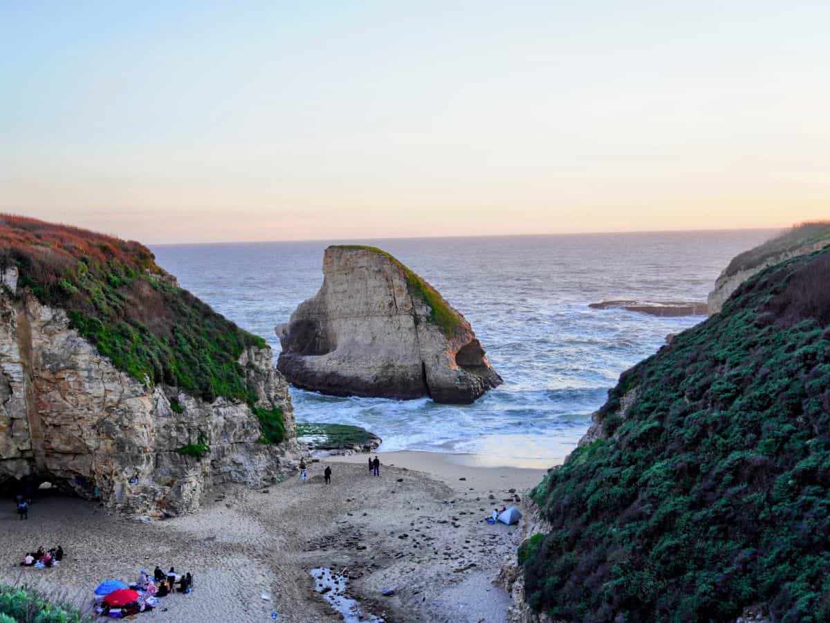 The dramatic landscape of Shark Fin Cove, with its distinctive shark fin-shaped rock jutting out from the ocean, nestled between steep cliffs, one of the more secluded spots among the 19 best beaches near Santa Cruz.