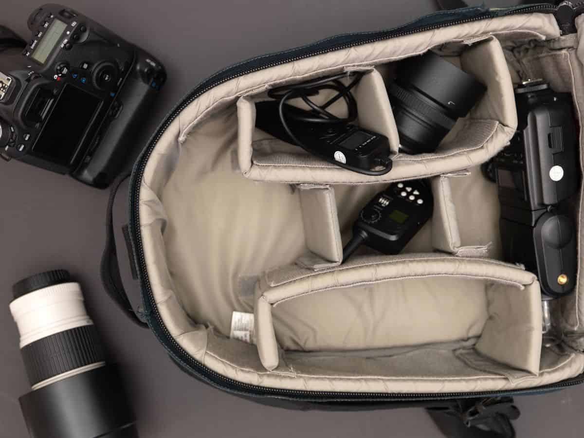 A camera backpack open with compartments organized for camera gear, including lenses and accessories. A well-organized camera backpack should be on your California packing list to safely carry your photography equipment.