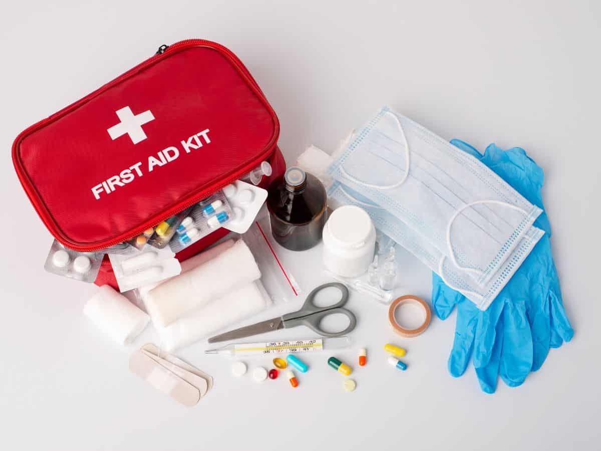A fully stocked red first aid kit with various medical supplies laid out. Packing a first aid kit is a wise choice for your California packing list to handle any minor injuries during your trip.
