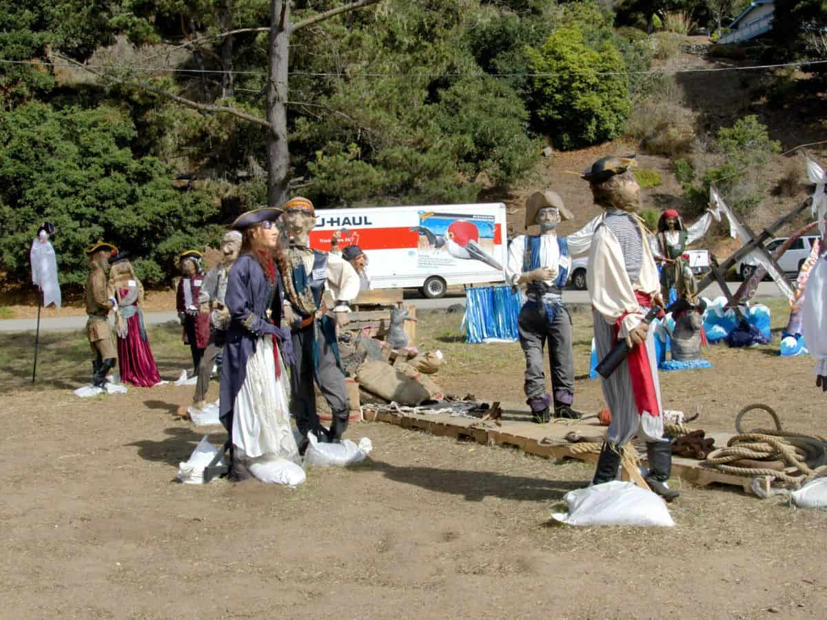 Whimsical scarecrow figures dressed as pirates on display at the Cambria Scarecrow Festival. Attending this charming festival is one of the fun things to do in California in October, where the town comes alive with creative scarecrow art.
