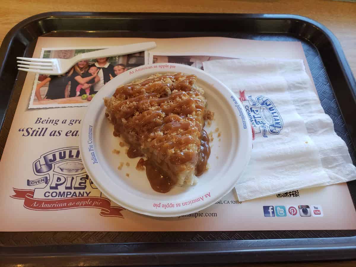 A plate of warm caramel apple pie from Julian Pie Company, served with a drizzle of caramel sauce. Tasting this iconic dessert is one of the most delicious things to do in California in October, especially for food lovers visiting Julian.