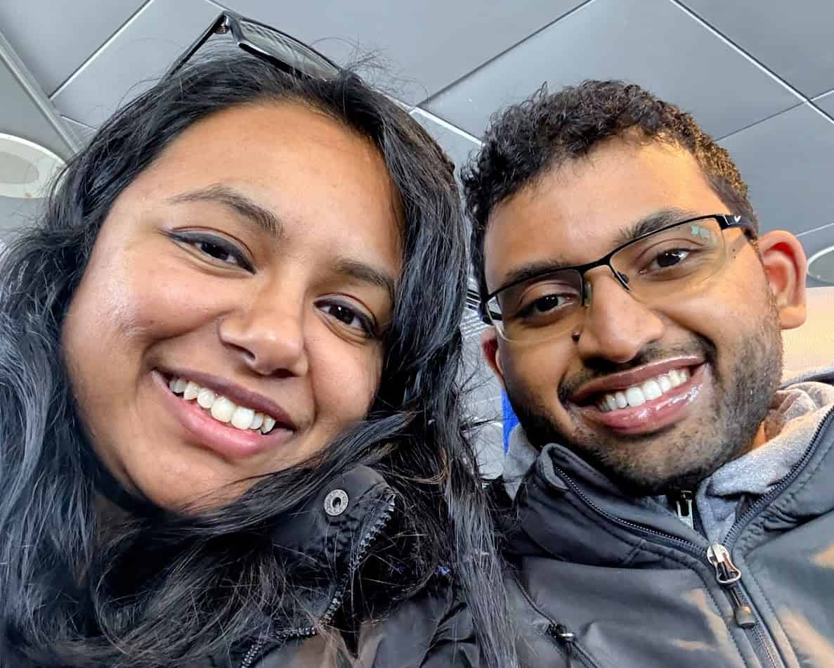 Shreeyeh and Kiran seated inside the Catalina Express ferry, surrounded by other passengers and bright blue cushioned seats, enjoying their journey.