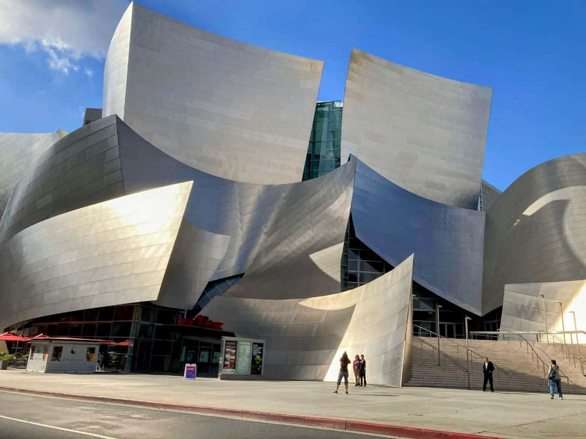 The stunning Walt Disney Concert Hall in Los Angeles, with its curving metallic architecture reflecting sunlight. This image showcases one of the many architectural attractions Los Angeles offers in the ongoing "San Francisco vs Los Angeles" debate.