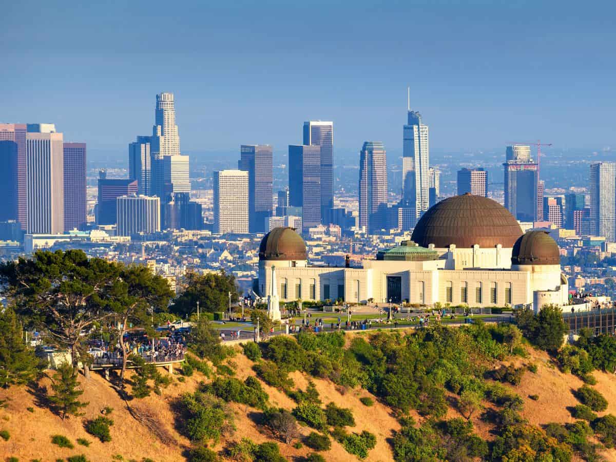 Griffith Observatory in Los Angeles with the downtown skyline in the background, showcasing the city’s iconic landmarks in comparison to Seattle’s cultural attractions in the Seattle vs Los Angeles attractions debate.