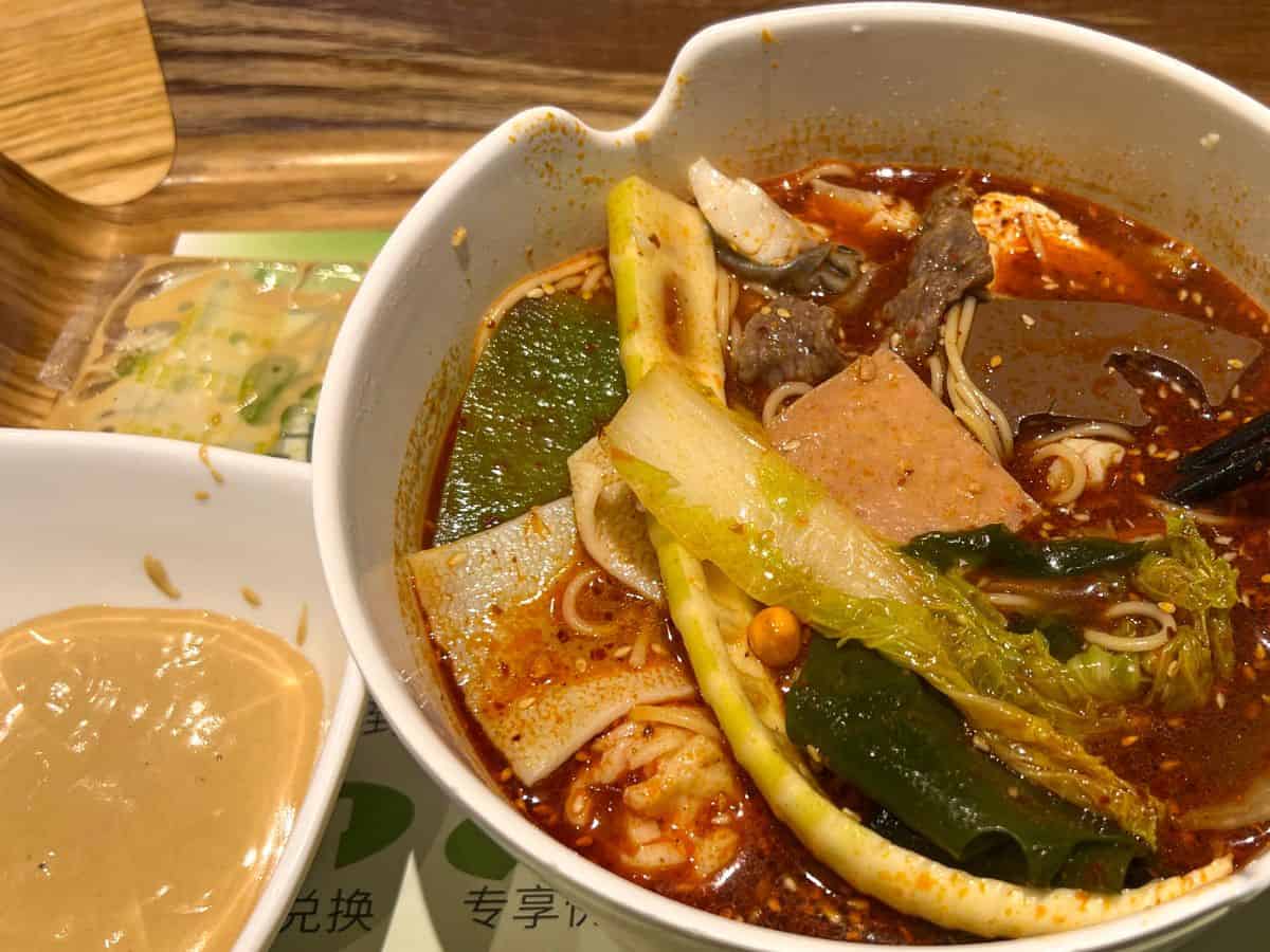 A vibrant and spicy hot pot brimming with an assortment of ingredients like sliced meats, noodles, vegetables, and mushrooms. The rustic presentation of the pot reflects the rich hot pot in San Francisco.