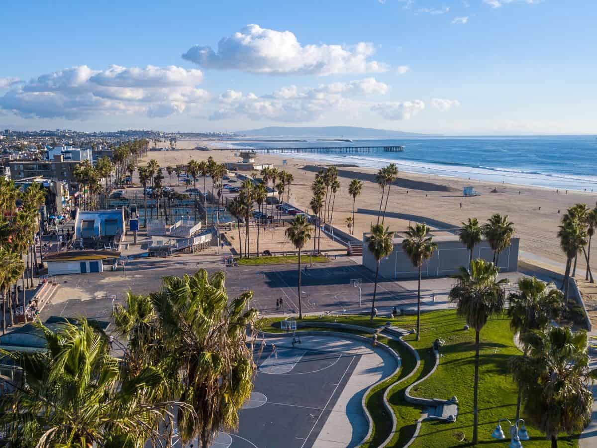  Aerial view of Venice Beach in Los Angeles with palm trees, clear skies, and the Pacific Ocean, representing the sunny weather of Los Angeles in contrast to Seattle’s rainy climate in the Seattle vs Los Angeles weather comparison.
