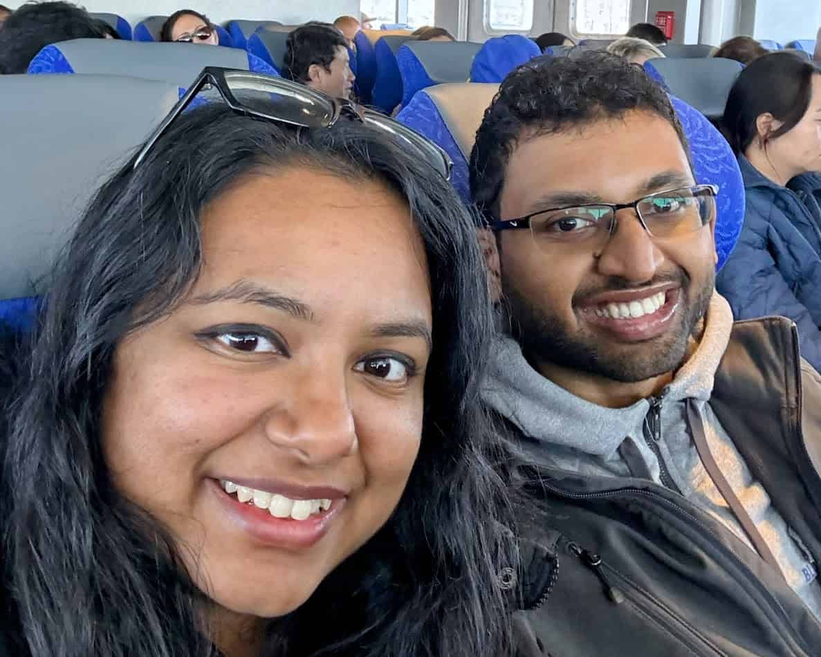 Shreeyeh and Kiran sitting in blue cushioned seats on the Catalina Express ferry, surrounded by other passengers enjoying the ride.