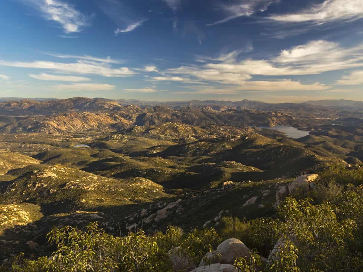 A breathtaking view from the Iron Mountain Trail showcasing rolling hills and valleys under a vivid blue sky, perfect for adventurous dog-friendly hikes in San Diego.