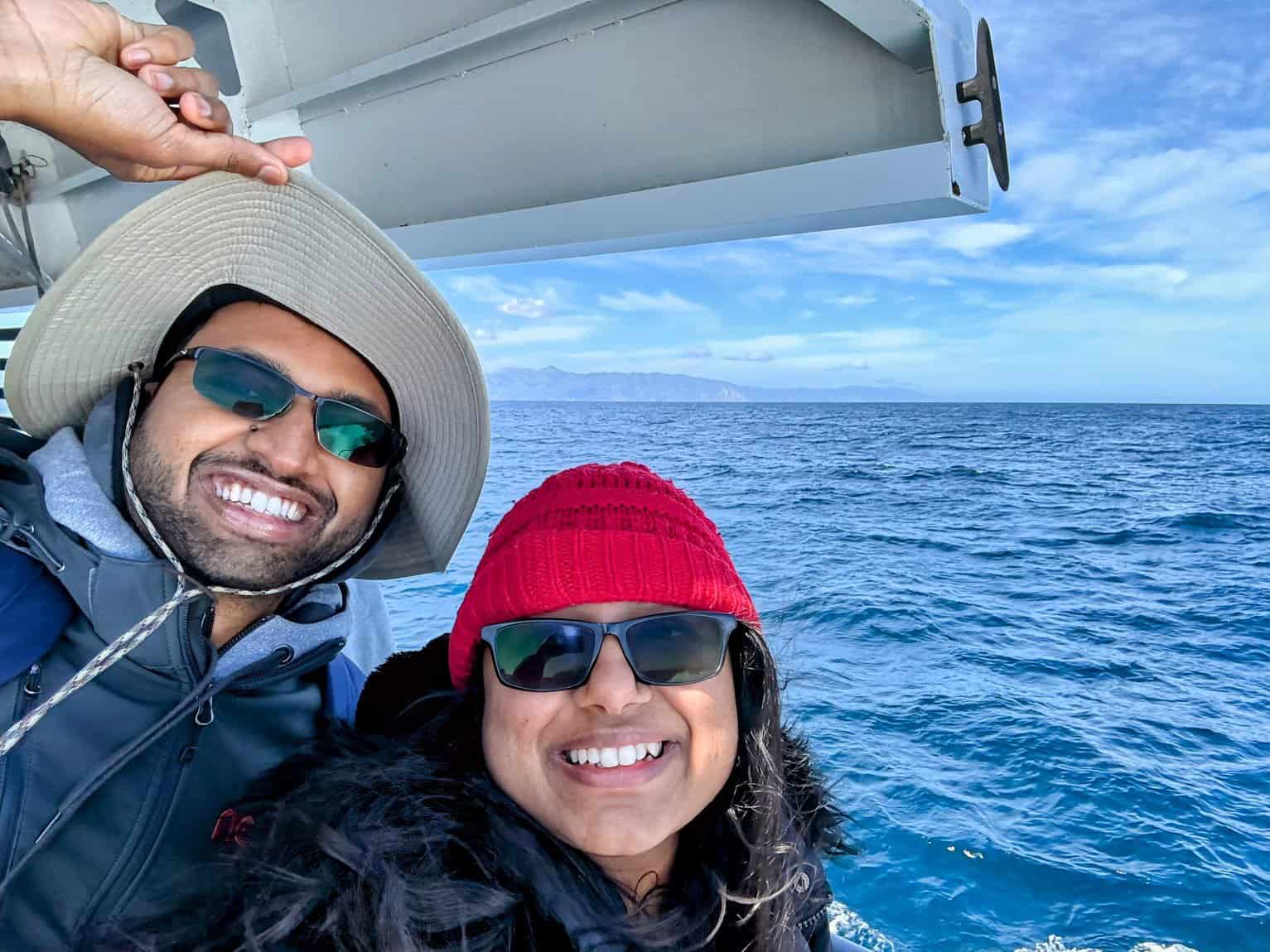 Kiran and Shreeyeh enjoying their ferry ride to Catalina Island, with bright ocean waves and distant mountains in the background.