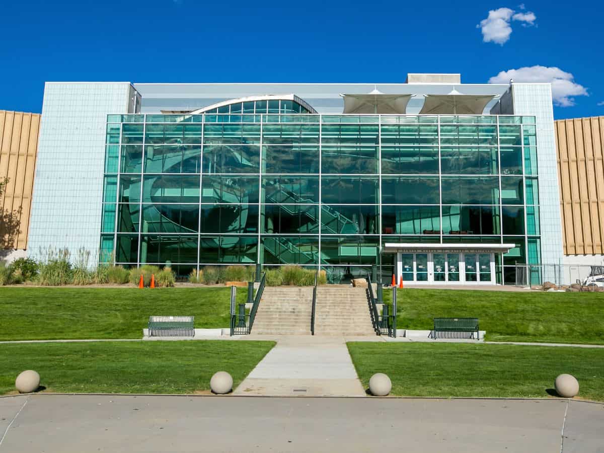 A modern, glass-fronted building under a clear blue sky, representing cultural and architectural attractions in Denver vs San Francisco. The building's design showcases the modernity and style found in these urban environments.
