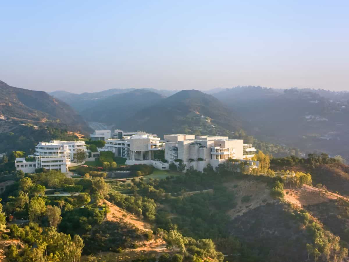 An aerial view of the Getty Center in Los Angeles, set amidst the hills and greenery. The architectural complex stands out against the natural landscape, illustrating one of the city's major cultural attractions when comparing Miami vs Los Angeles.