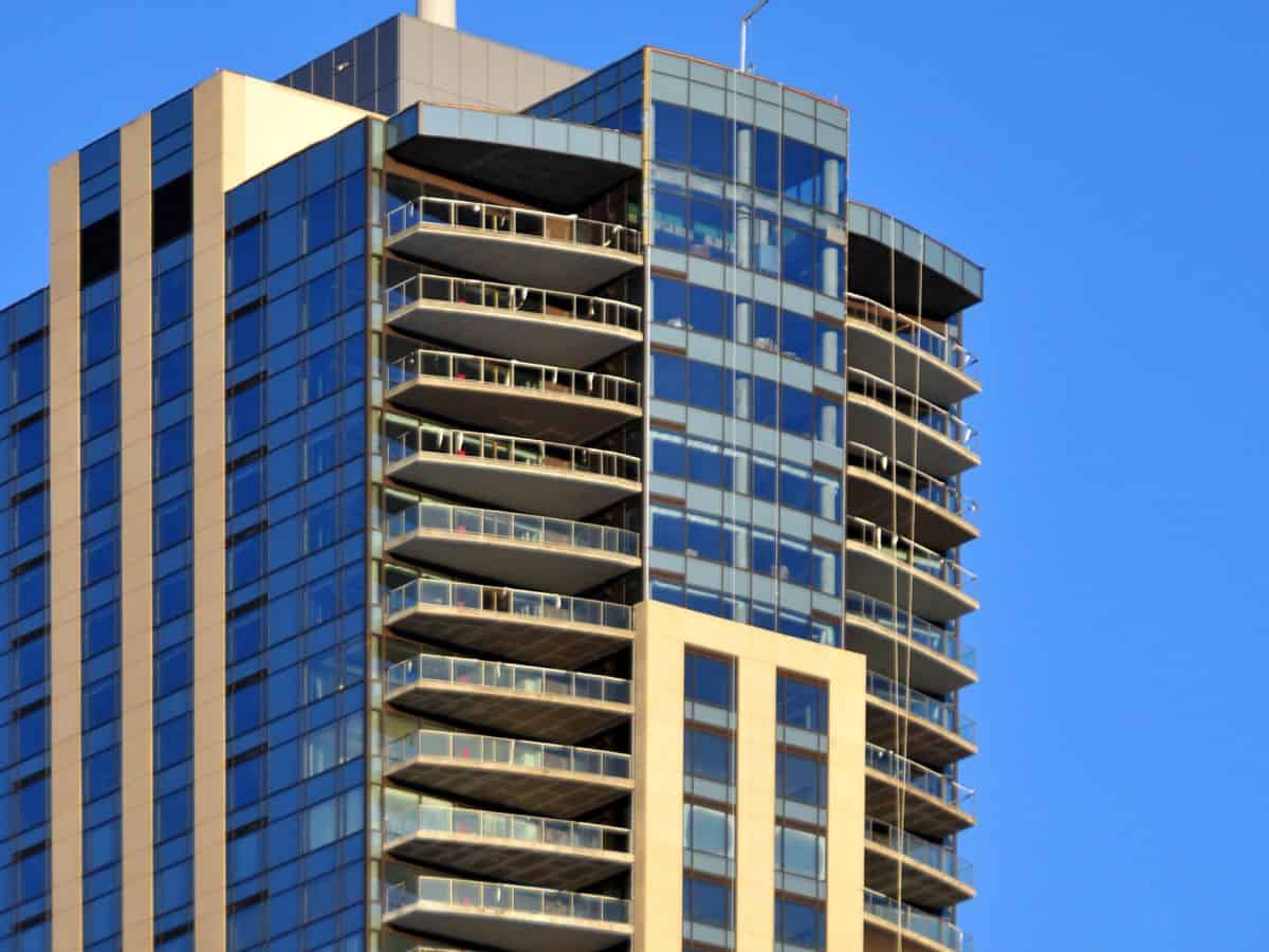 A close-up of a modern high-rise building with balconies, symbolizing lodging options in Denver vs San Francisco. The image contrasts the types of accommodations available in both cities.