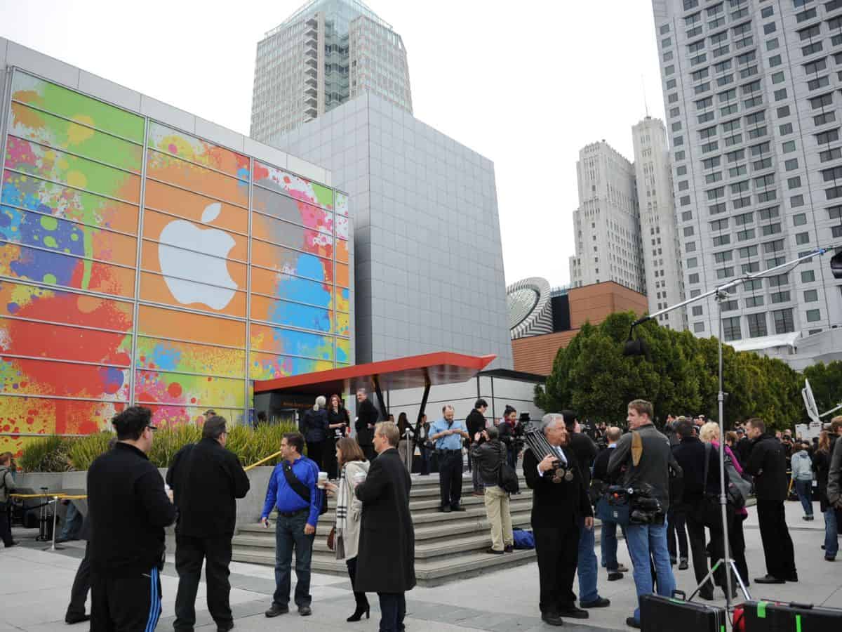 A couple lounging on a grassy hill with San Francisco's Painted Ladies in the background, representing the quality of life in Denver vs San Francisco. The image conveys a sense of relaxation, leisure, and urban beauty.