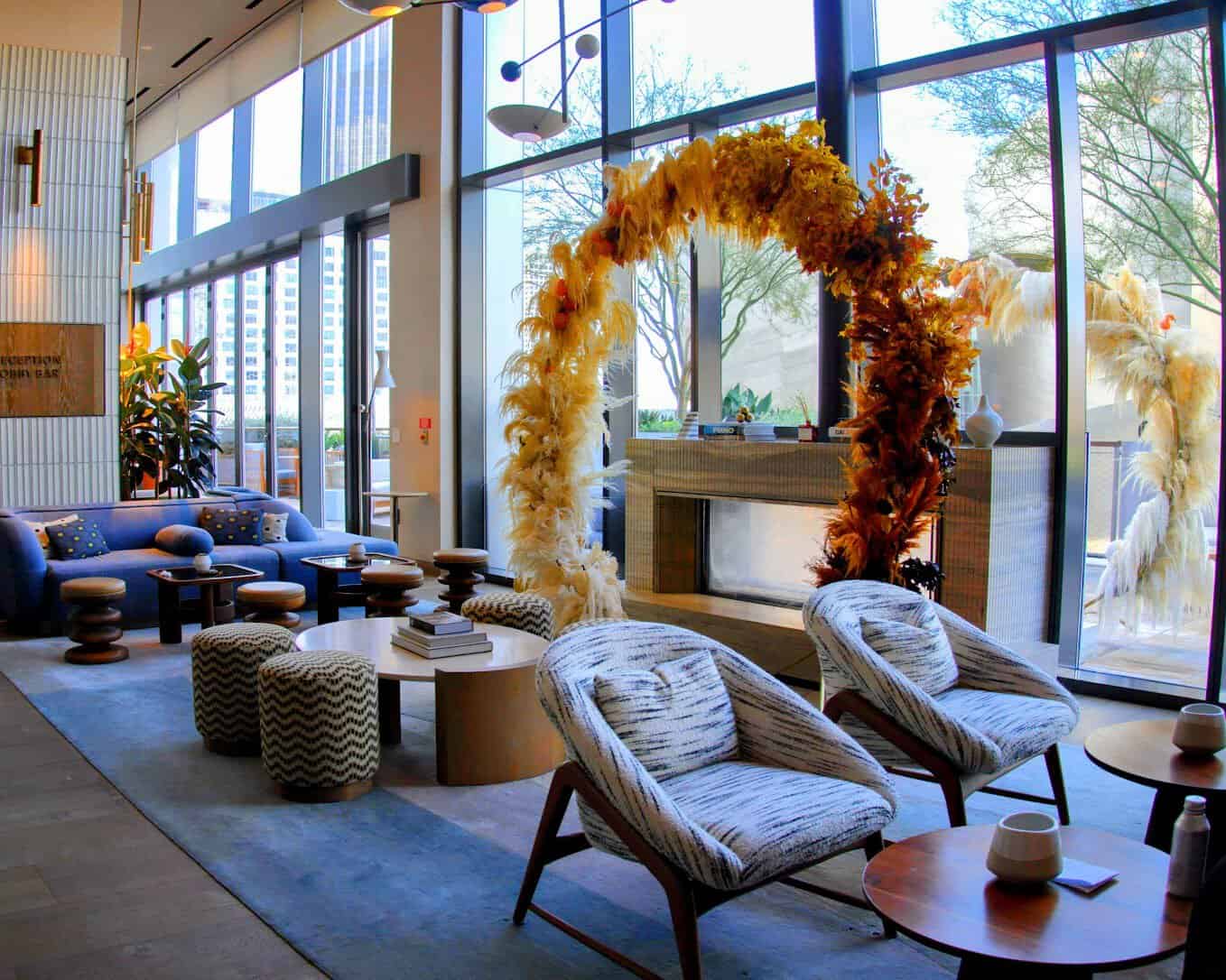 The stylish lobby at Conrad Los Angeles, showcasing modern furniture, bold decor, and floor-to-ceiling windows with city views.