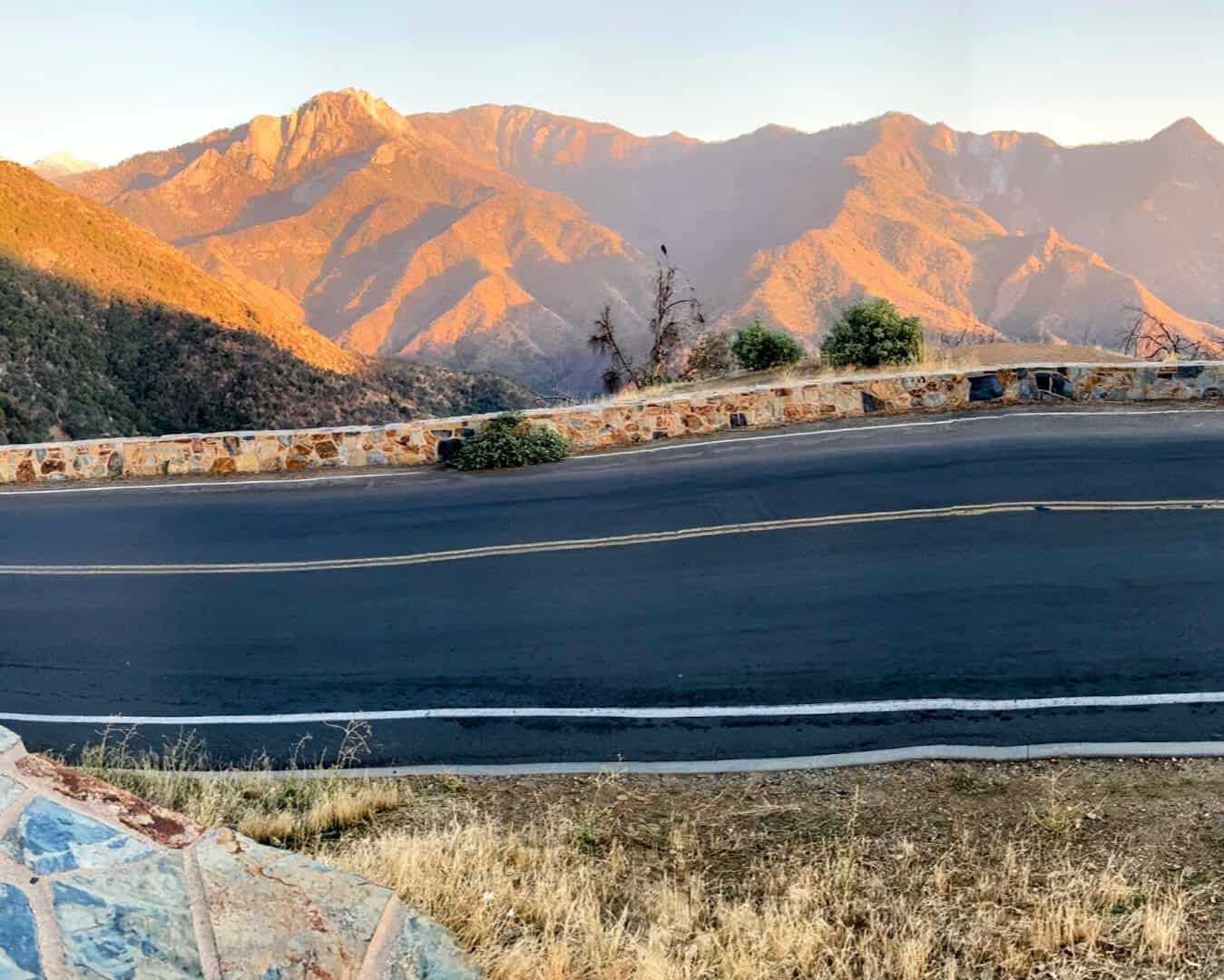 Landscape of a mountain range bathed in golden light during sunset, showcasing the serene and untouched beauty of the park's topography.