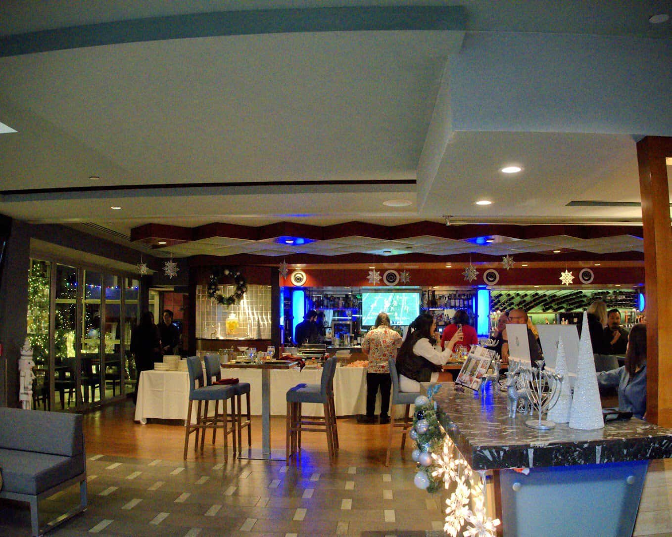 The elegant bar area at Shade Hotel in Los Angeles, adorned with modern lighting, festive decor, and an inviting social atmosphere.