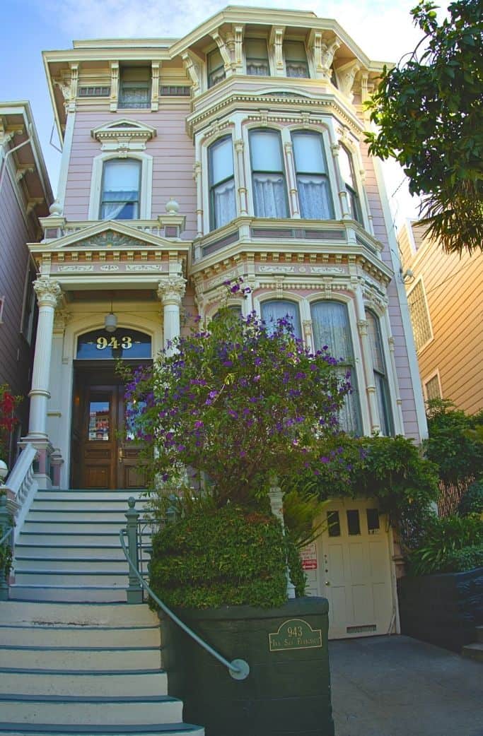 A classic Victorian-style house with ornate architectural details and a lush garden, capturing the charm and elegance of historical San Francisco neighborhoods.