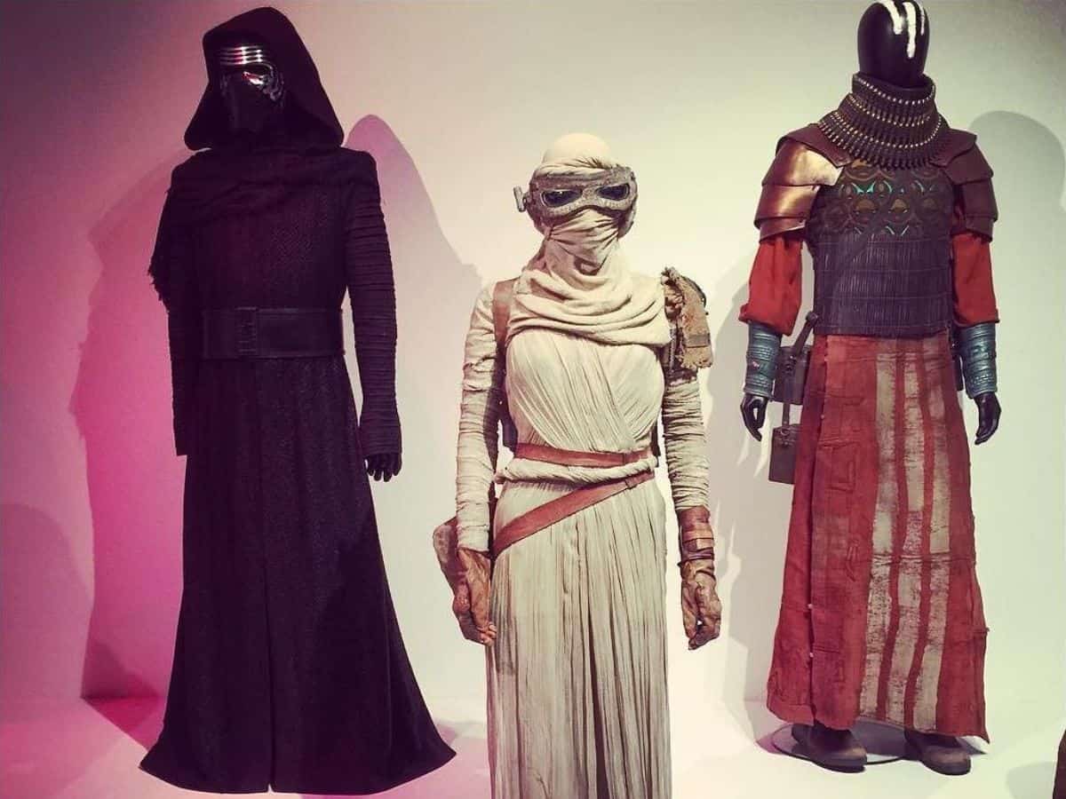 Mannequins dressed in intricate costumes from popular films, including a character wearing a black cloak, another in desert survival gear, and a third in an elaborate metallic and red outfit.