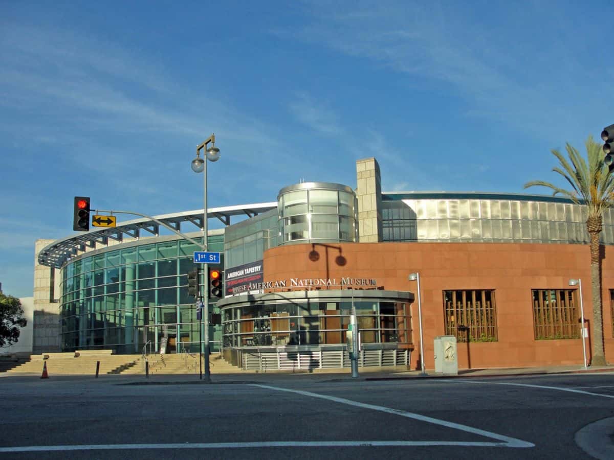 A modern building with curved glass architecture and a red brick façade under a clear blue sky.