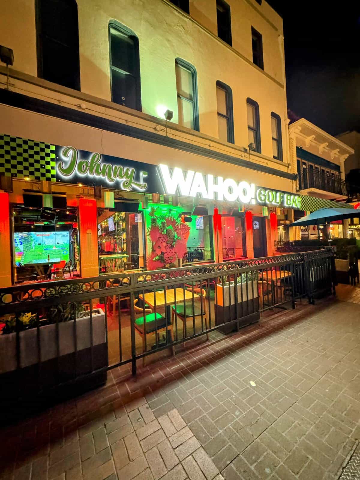 Swing Social also known as Johnny Wahoo's Golf Bar illuminated at night with neon lights, a fun place with indoor golf, part of the best bars in Gaslamp Quarter San Diego
