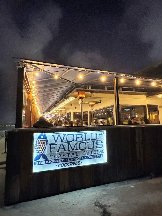 World Famous, a highlight among the best restaurants in Pacific Beach San Diego, seen at night with its name lit up above the entrance, inviting guests in for coastal cuisine and cocktails