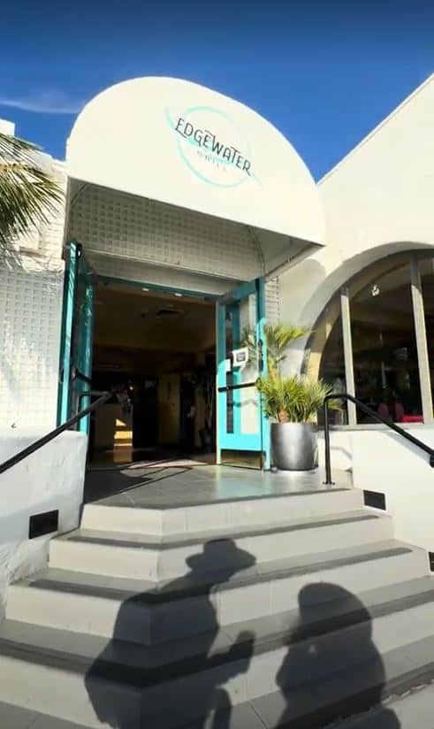 Exterior shot of Edgewater Grill with its sleek modern design and turquoise colored doors, a popular pick among the best Seaport Village restaurants