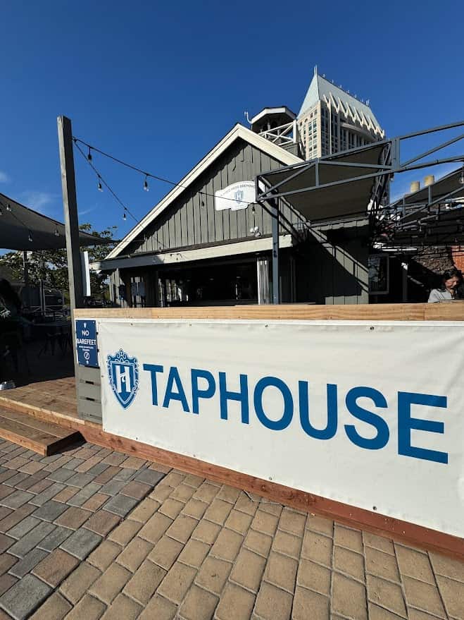 Outdoor patio seating of Mike Hess Brewing with customers enjoying the sunny ambiance