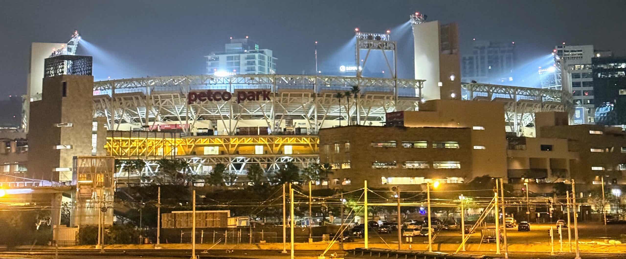 A night view of Petco Park lit up, one of the best things to do in Gaslamp Quarter San Diego, with city buildings in the background.