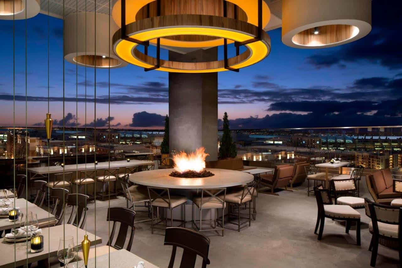 A rooftop restaurant with a flaming fire pit and huge lamps at Courtyard by Marriott, one of the best hotels in Gaslamp Quarter San Diego.