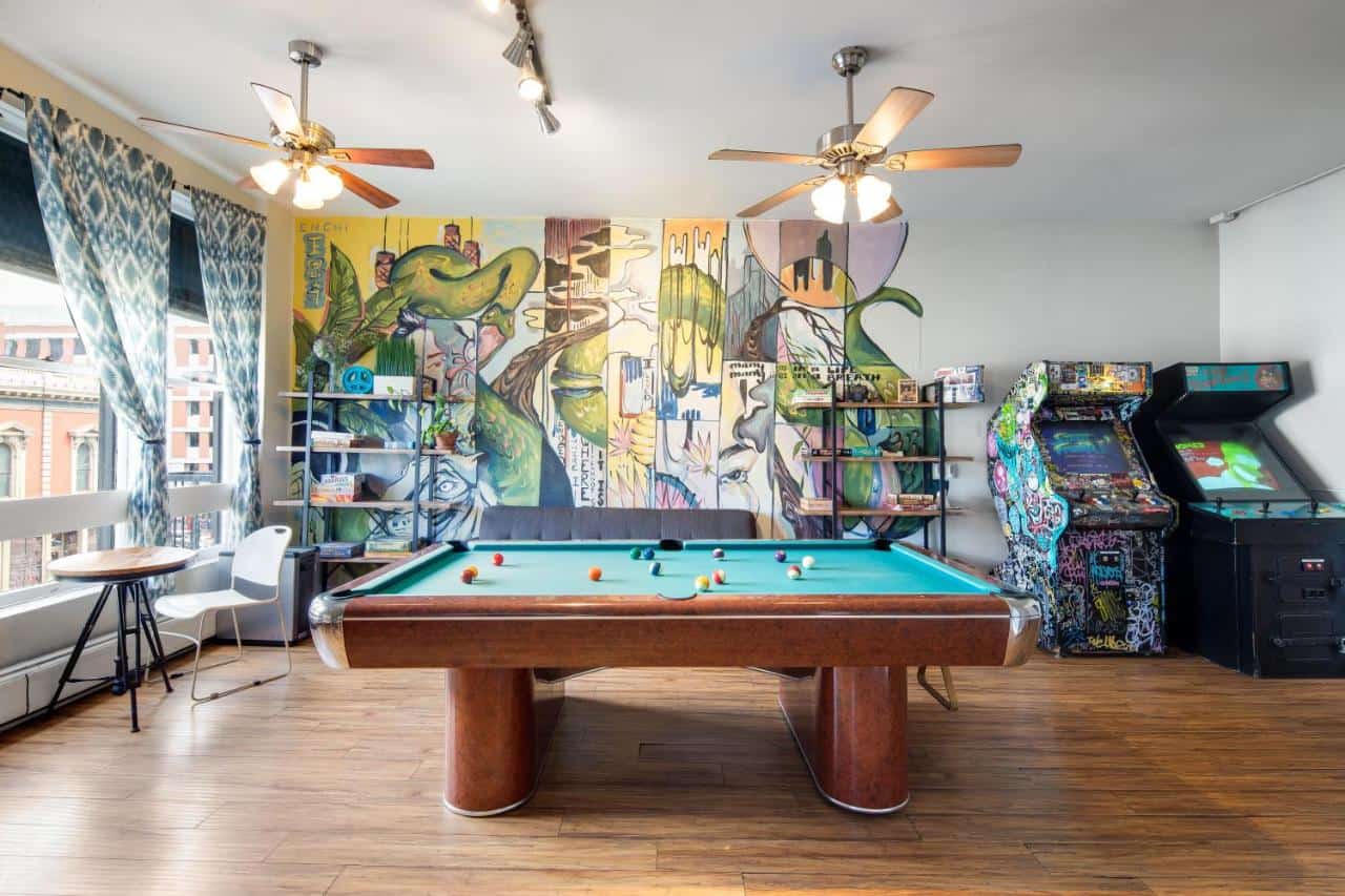 A hotel game room with a pool table and arcade games in HI San Diego Downtown Hostel, one of the best places to stay in Gaslamp Quarter San Diego.