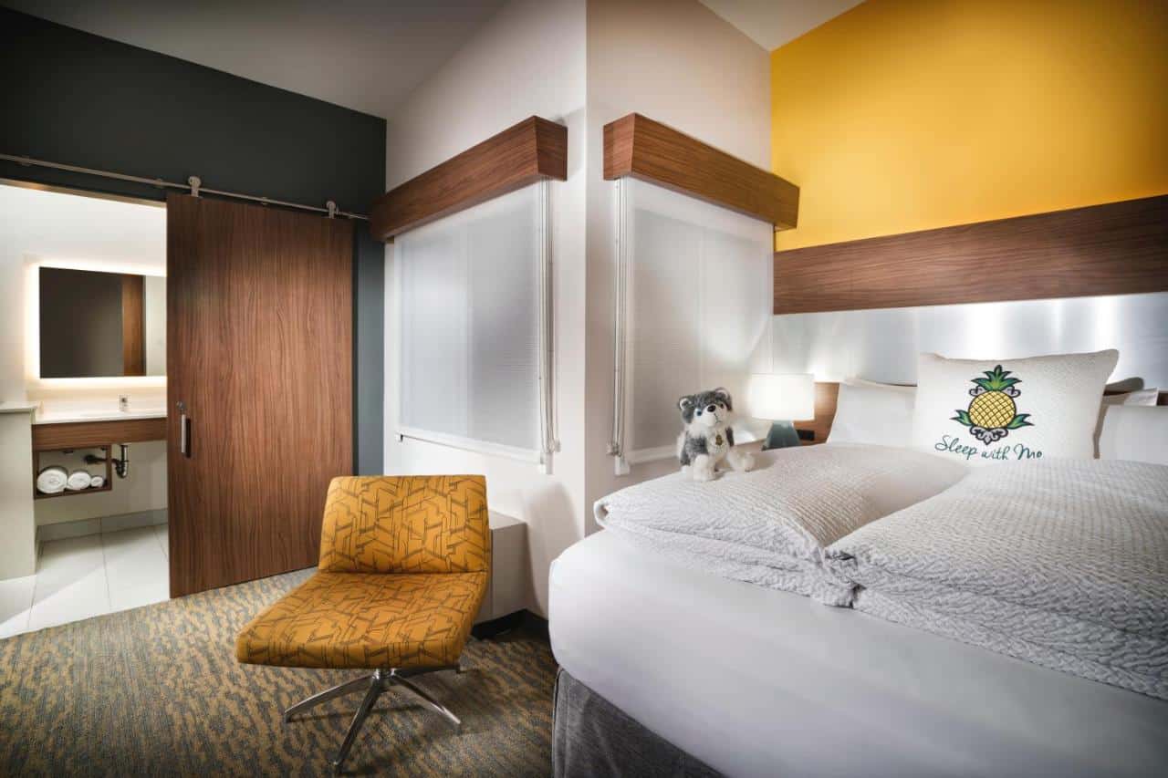 A cozy hotel room with a cute stuffed dog on the bed, inviting for those looking for where to stay in Gaslamp Quarter San Diego."