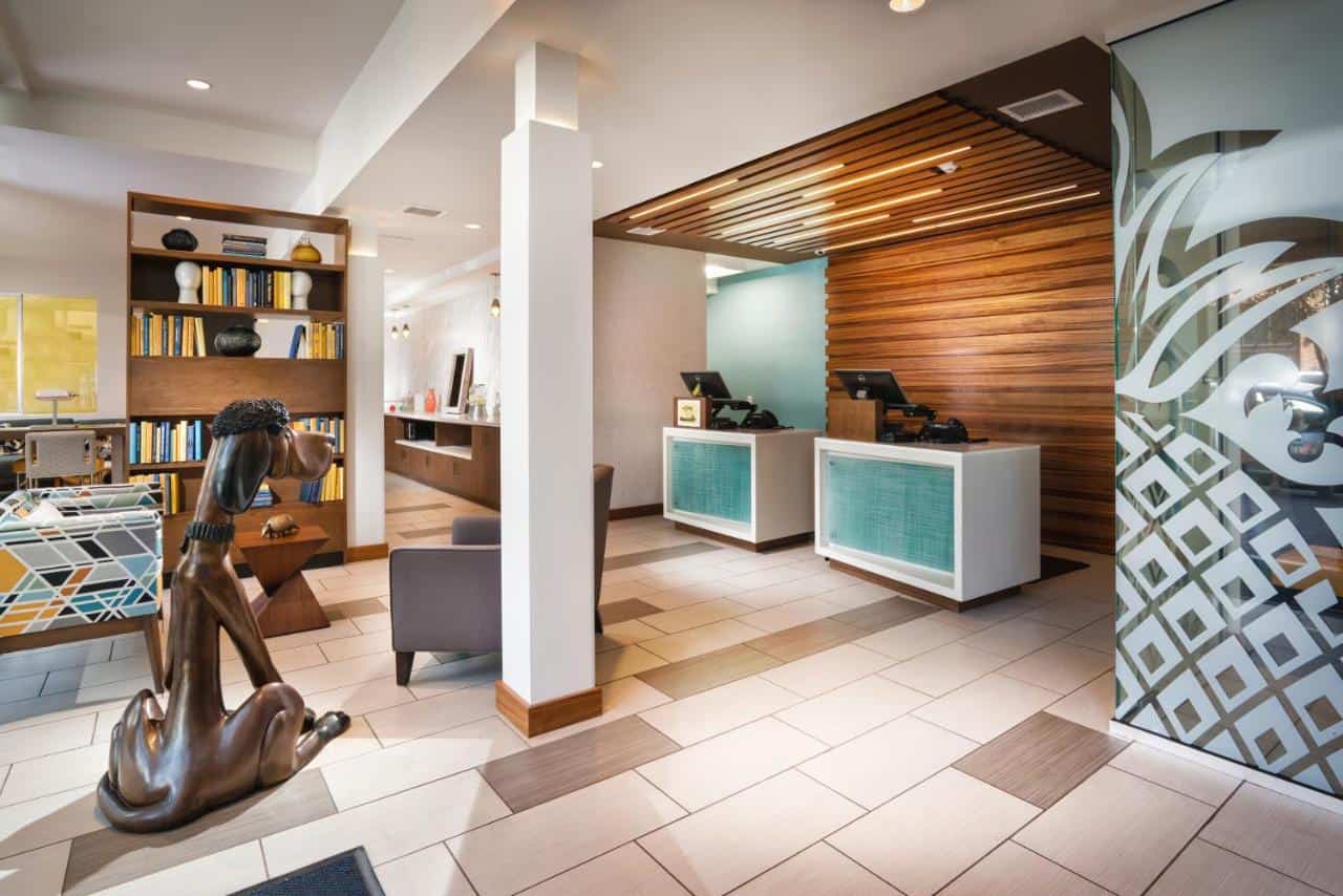 A modern hotel lobby with artsy decor and a wood-accented front desk, welcoming guests figuring out where to stay in Gaslamp Quarter San Diego.