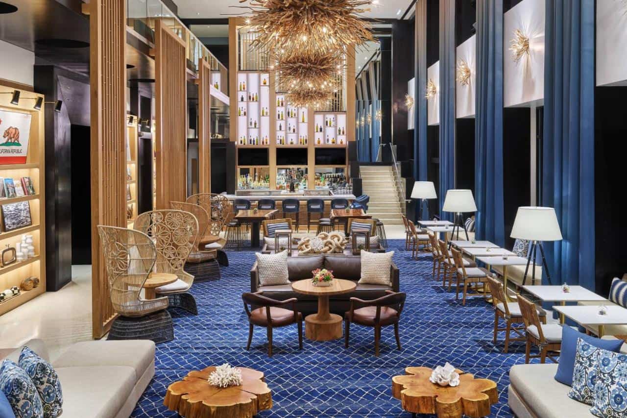 Chic hotel lounge with elegant blue and gold accents, sophisticated seating arrangements, and an elaborate chandelier