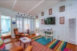 Bright and colorful living room inside one of the best Airbnbs in Ocean Beach San Diego, showcasing a vibrant striped rug, modern decor, and a welcoming, cozy atmosphere for guests
