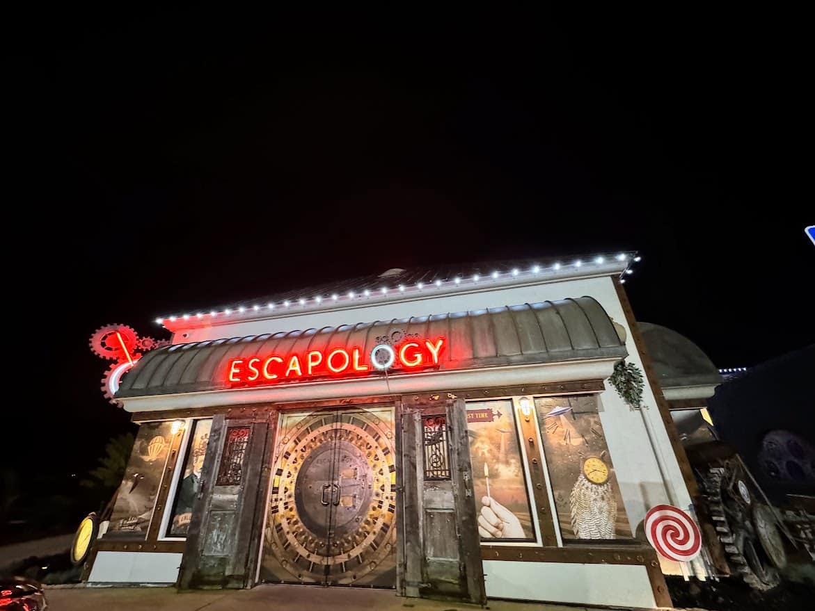 The exterior of Escapology at Belmont Park, an exciting escape room adventure with a neon sign and themed decor, highlighting one of the thrilling things to do in Belmont Park, Mission Beach.