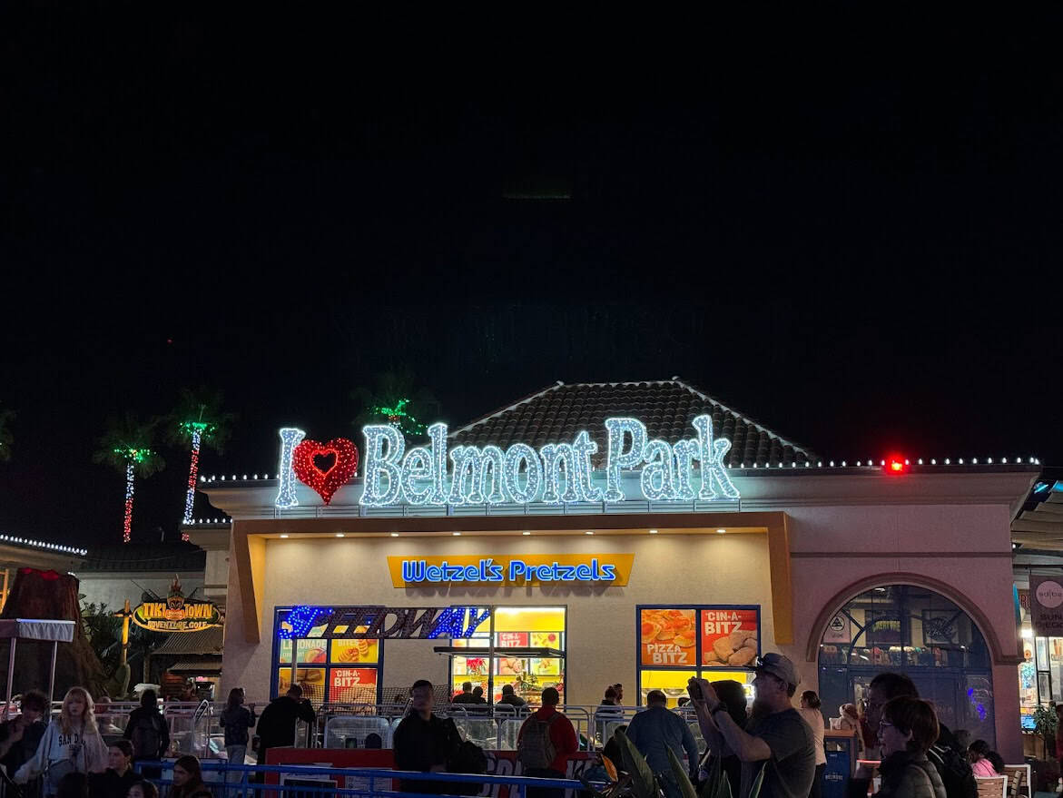 The brightly lit "I Love Belmont Park" sign at night, with people gathered around, capturing the lively atmosphere and one of the popular things to do in Belmont Park, Mission Beach.