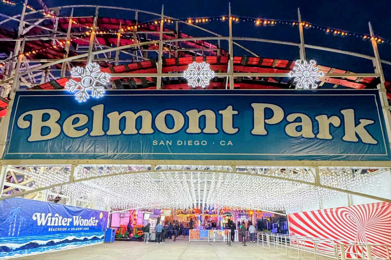 The illuminated entrance sign of Belmont Park at night, adorned with twinkling lights and festive decorations, inviting visitors to explore the various attractions and things to do in Belmont Park, Mission Beach.