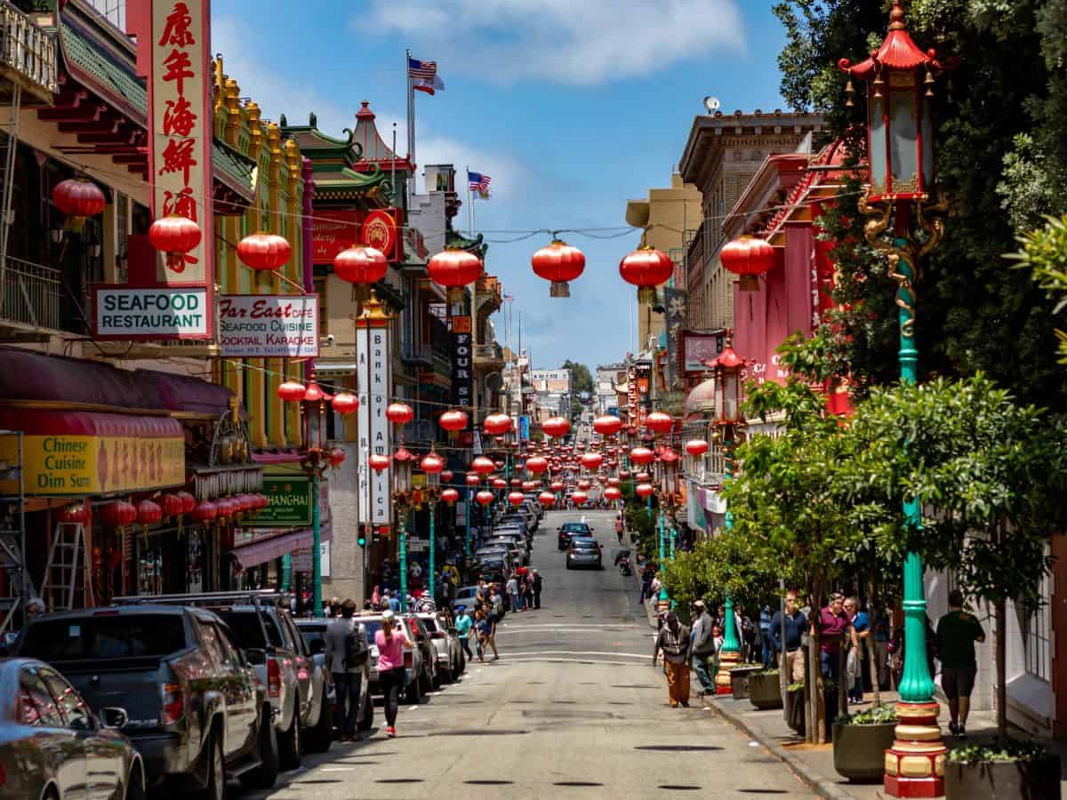 A vibrant street scene in San Francisco's Chinatown, adorned with red lanterns and bustling with people. Visiting Chinatown is a colorful and cultural highlight of things to do in San Francisco.