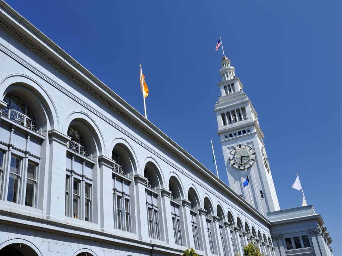 The bustling Ferry Building Marketplace in San Francisco viewed from the outside, showing the busy waterfront area. This marketplace is a vibrant spot for shopping and dining, making it a lively thing to do in San Francisco.