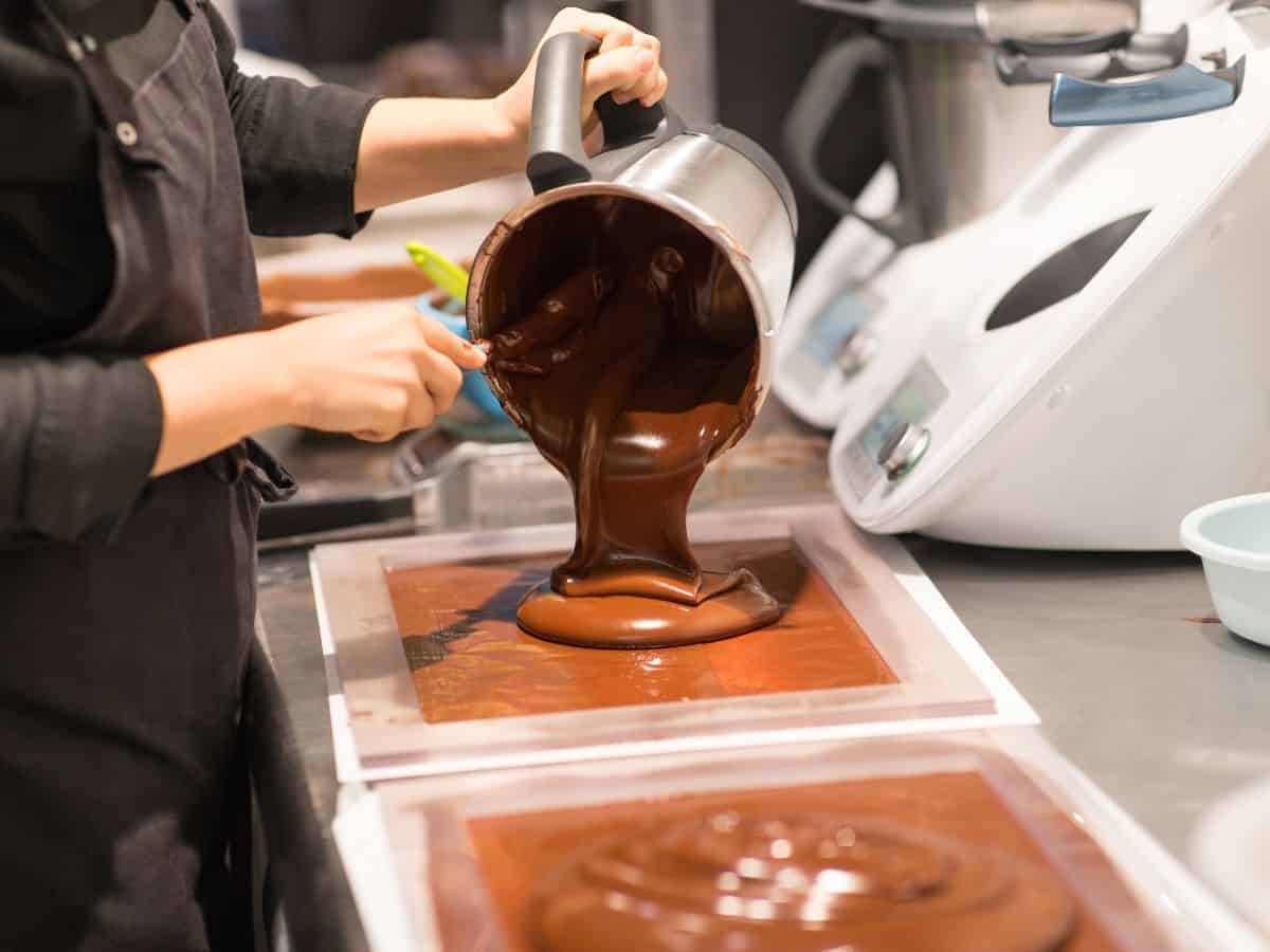 A chocolatier pours molten chocolate into molds. Ghirardelli Chocolate Company, a must-visit for chocolate lovers exploring tasty things to do in San Francisco.