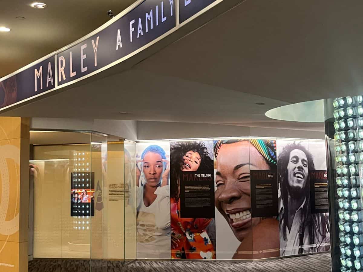 An exhibit in the Grammy Museum dedicated to Bob Marley and his family, featuring large photos of the legendary musician and his family members, alongside information about their lives and influence on music.