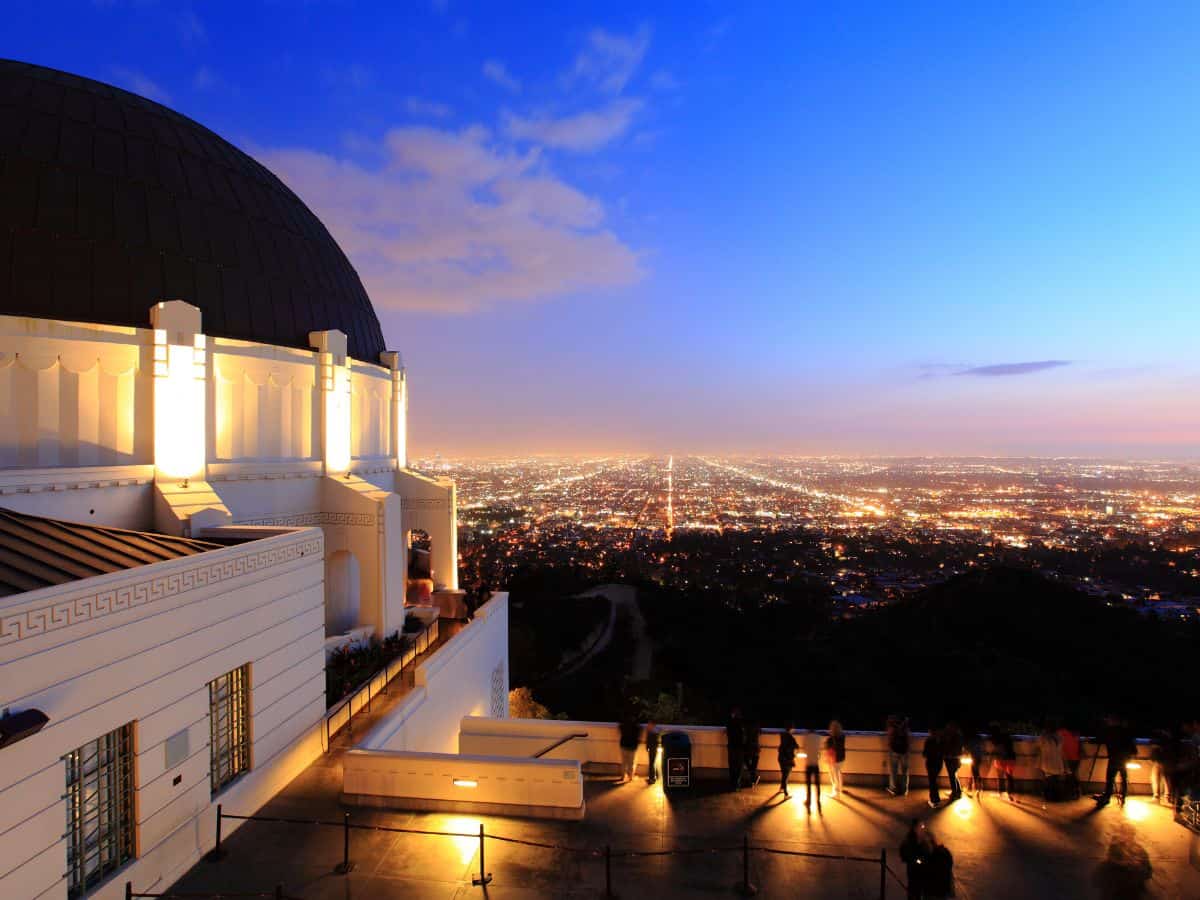 Evening view from Griffith Observatory overlooking the vast Los Angeles cityscape illuminated by city lights under a dusky sky, highlighting one of the most scenic things to do in Los Angeles.