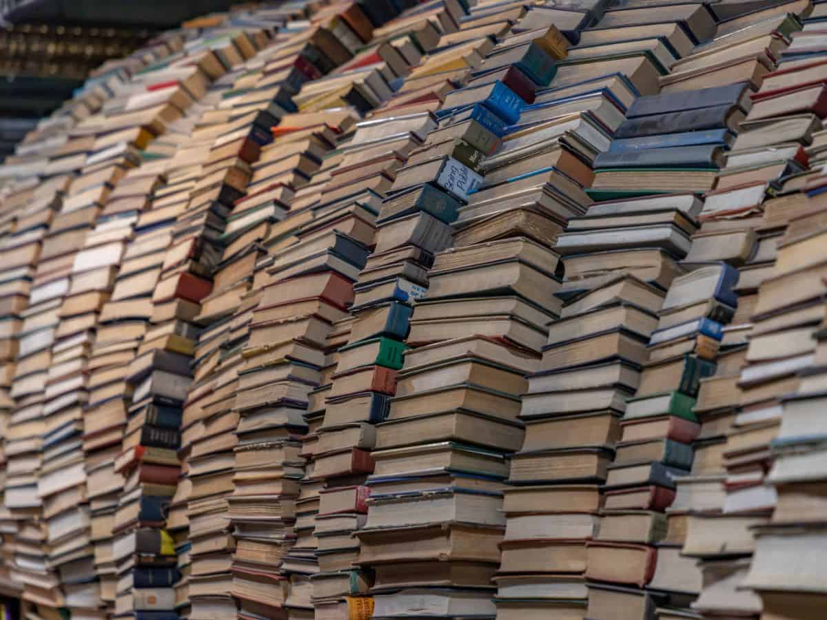 An artistic shot inside The Last Bookstore, showcasing a large, chaotic yet intriguing pile of books creating a circular labyrinth.
