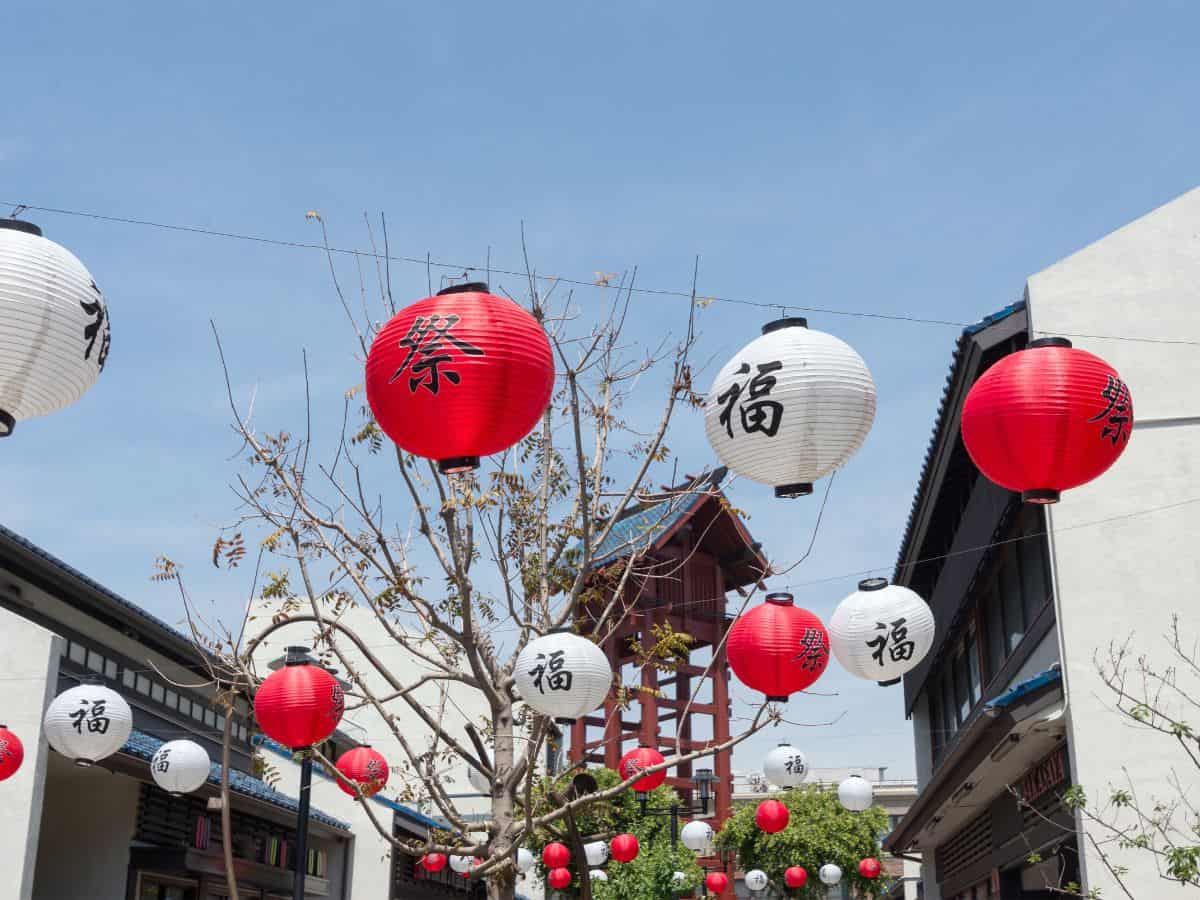 Vibrant red and white lanterns strung across a street in Little Tokyo, Los Angeles, with traditional architecture in the background, representing cultural things to do in Los Angeles.