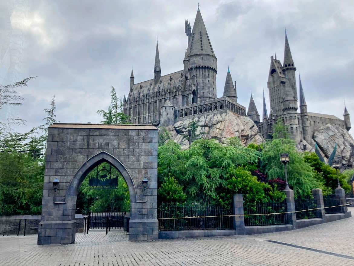 Magical view of the Hogwarts castle at Universal Studios Hollywood, surrounded by lush greenery and dramatic rock formations, a must-see attraction for fans and a popular thing to do in Los Angeles.