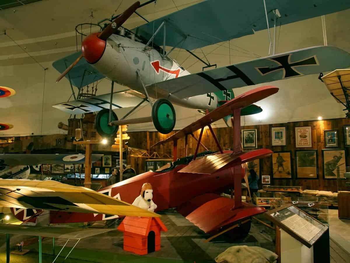 Vintage airplanes on display in the Air & Space Museum in San Diego, showcasing historical aircraft and a Snoopy statue, a unique educational attraction among things to do in San Diego.