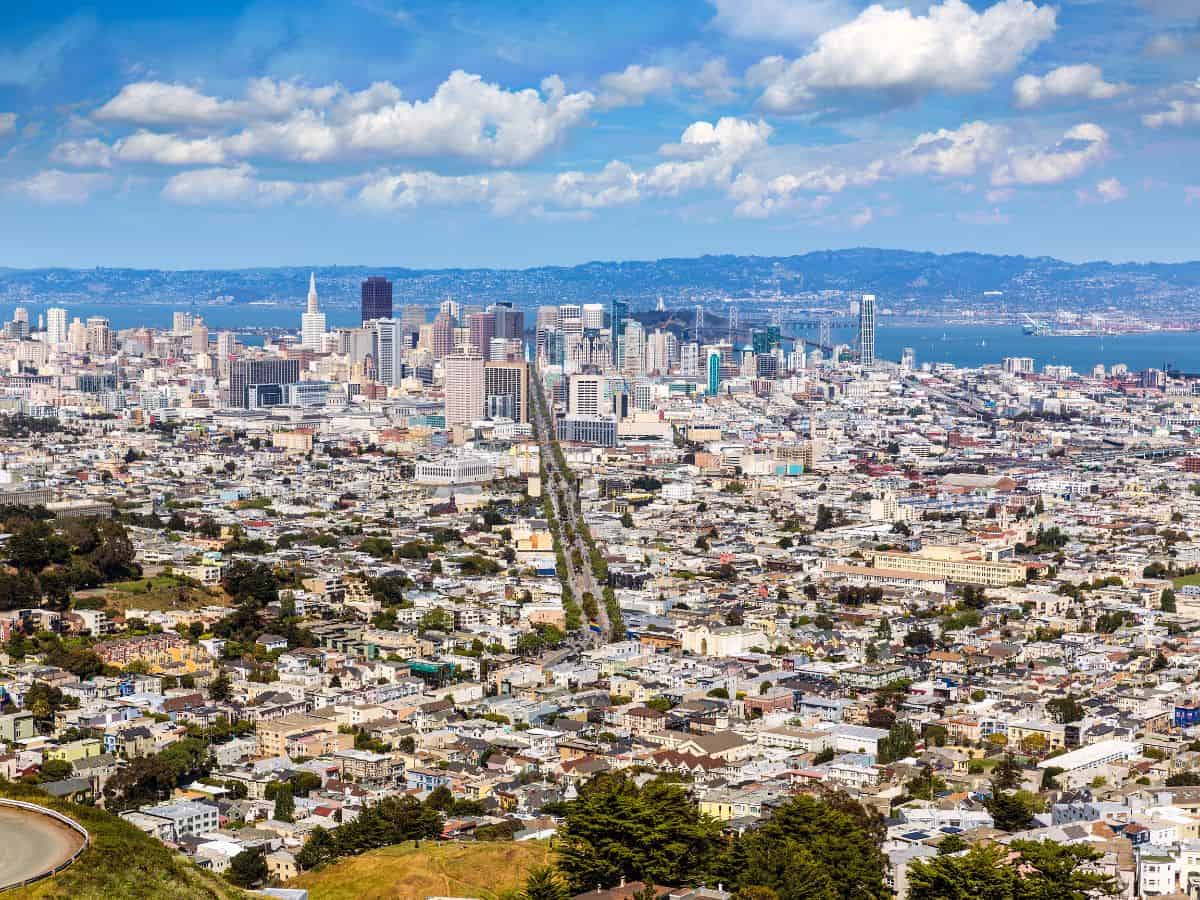 A panoramic view from Twin Peaks overlooking San Francisco's expansive cityscape, showing dense urban areas leading into the bay. Exploring Twin Peaks offers one of the best vantage points and is a favorite among things to do in San Francisco.