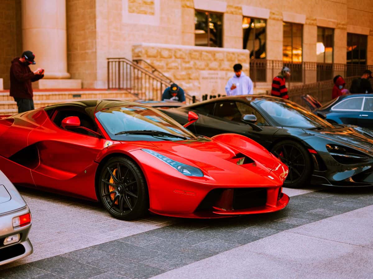 A lineup of luxury cars on display in an upscale area. The high ownership of expensive vehicles in California leads to higher insurance costs, explaining why California is so expensive.