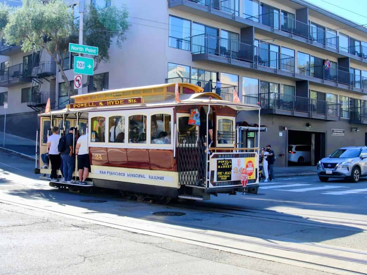 A San Francisco cable car packed with passengers, showcasing the iconic public transport of the city. This image highlights the bustling atmosphere of the city, which is often compared to Seattle in "Which City Is Truly the West Coast’s Best? 13 Key Comparisons Between Seattle and San Francisco.