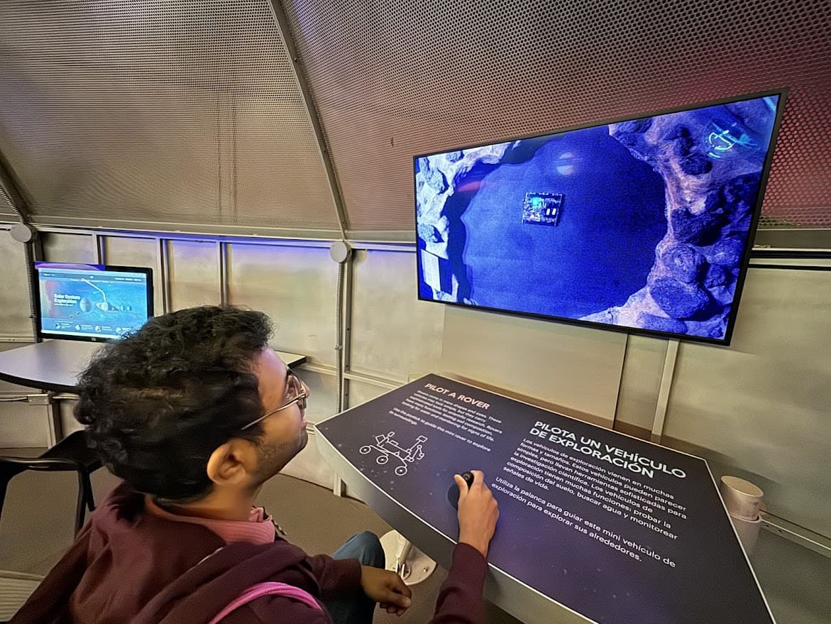 Kiran interacts with a Mars Rover simulation at The Tech Interactive, showcasing how rovers explore difficult terrains.